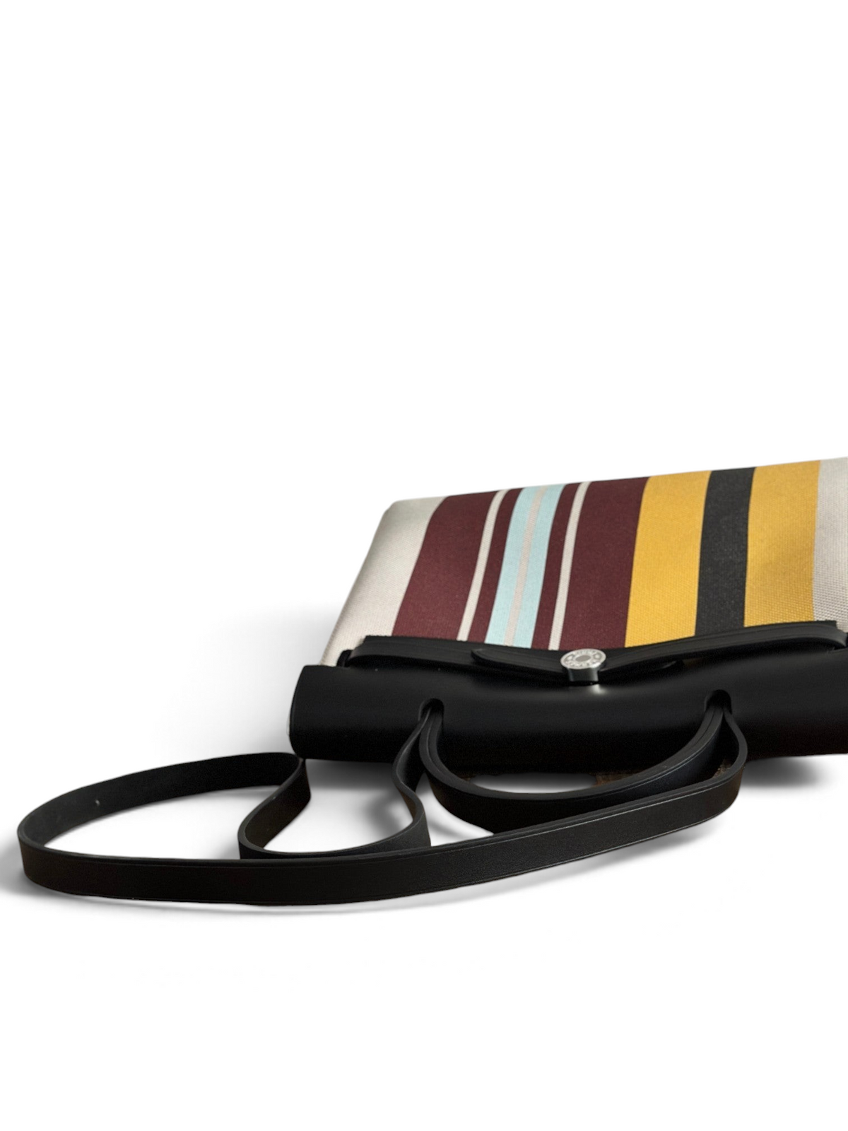 SWORD LUXURY Hermès Herbag 31 çanta, siyah deri kapaklı ve renkli çizgili kanvas gövdeli, şık ve modern tasarım.