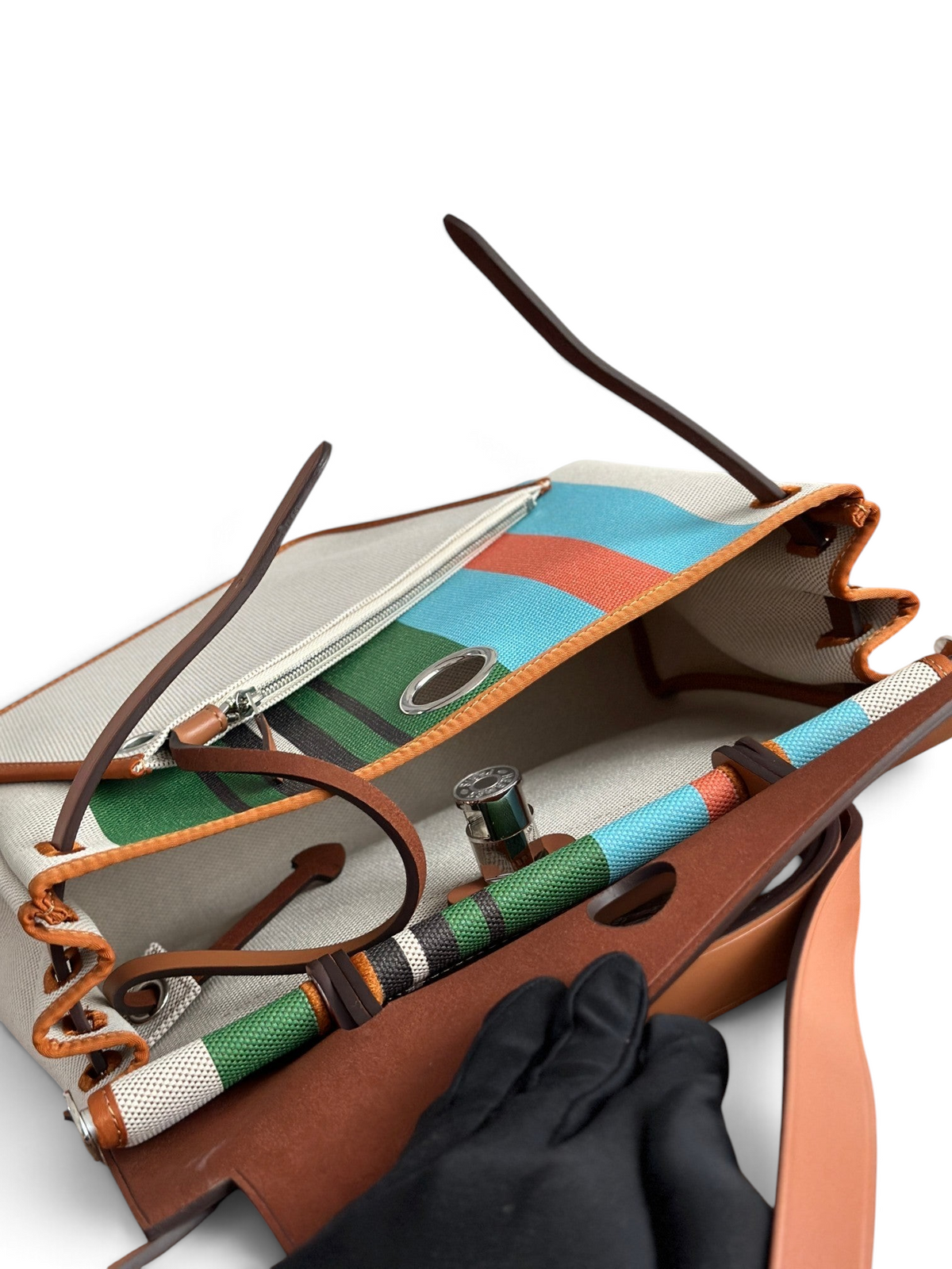 SWORD LUXURY Hermès Herbag 31 çanta, renkli desenli kanvas gövde ve kahverengi deri detaylara sahip açık iç görünüm.