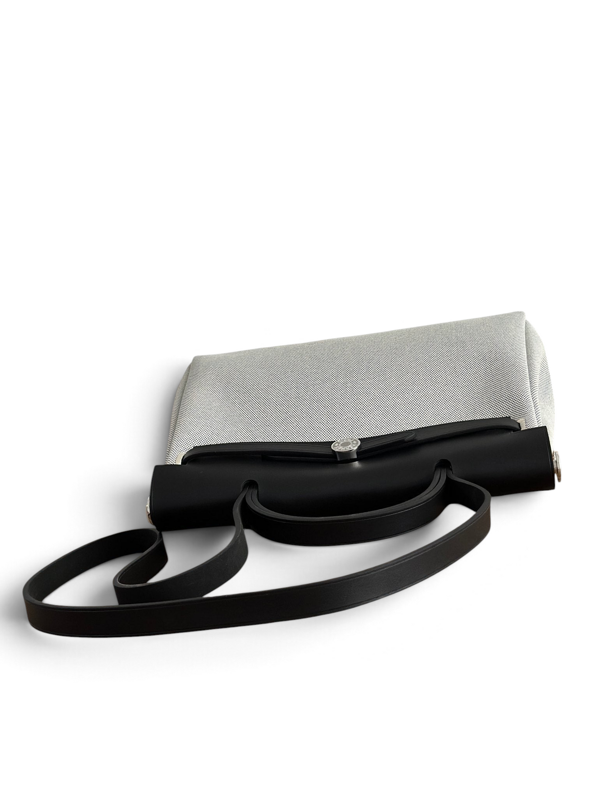 SWORD LUXURY Herbag 31 çanta, siyah deri kapaklı ve beyaz kanvas gövdeli, şık ve modern bir tasarım.