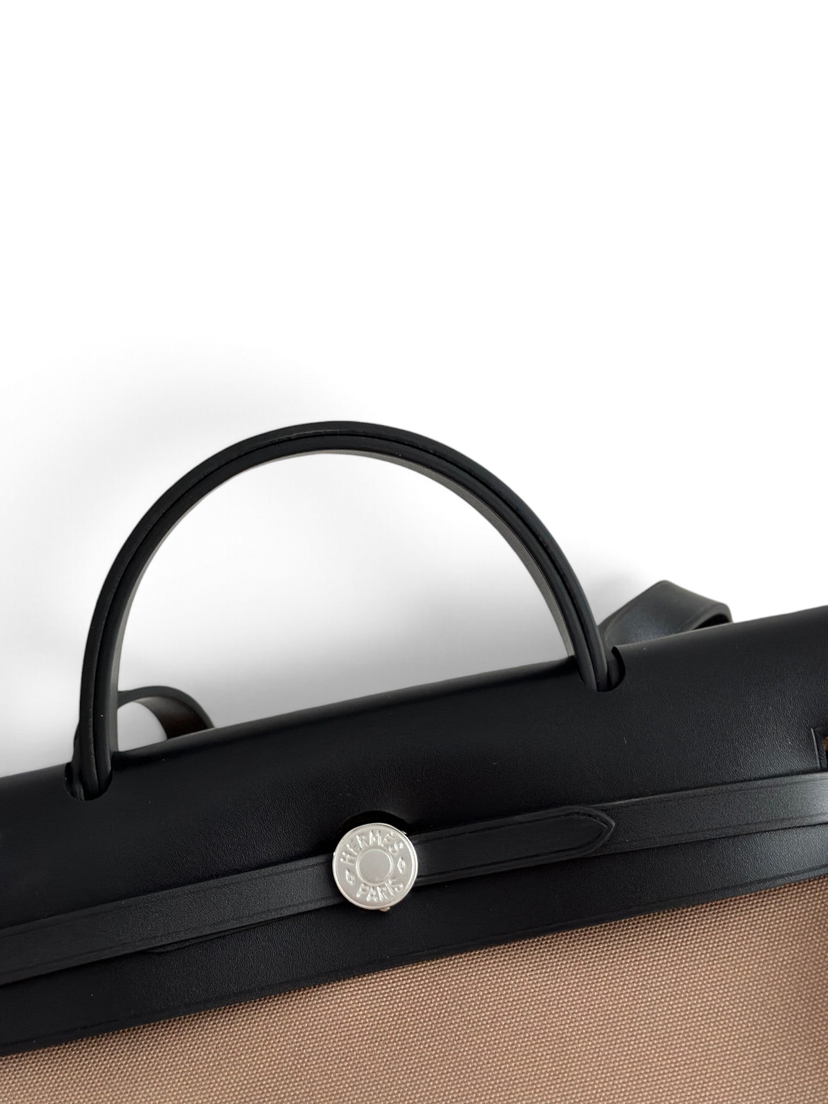 SWORD LUXURY Hermès Herbag 31 siyah deri kapaklı ve kanvas gövdeli, gümüş Clou de Selle kilit detaylı el çantası.