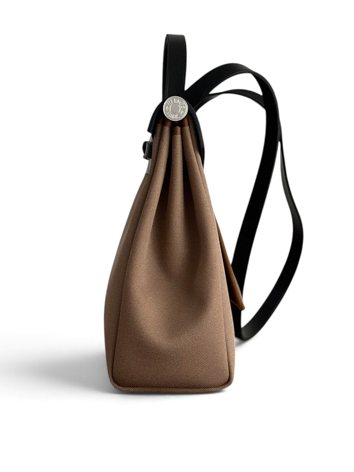 SWORD LUXURY Hermès Herbag 31 çanta, kahverengi kanvas gövde ve siyah deri detaylı yan profil görünümü.