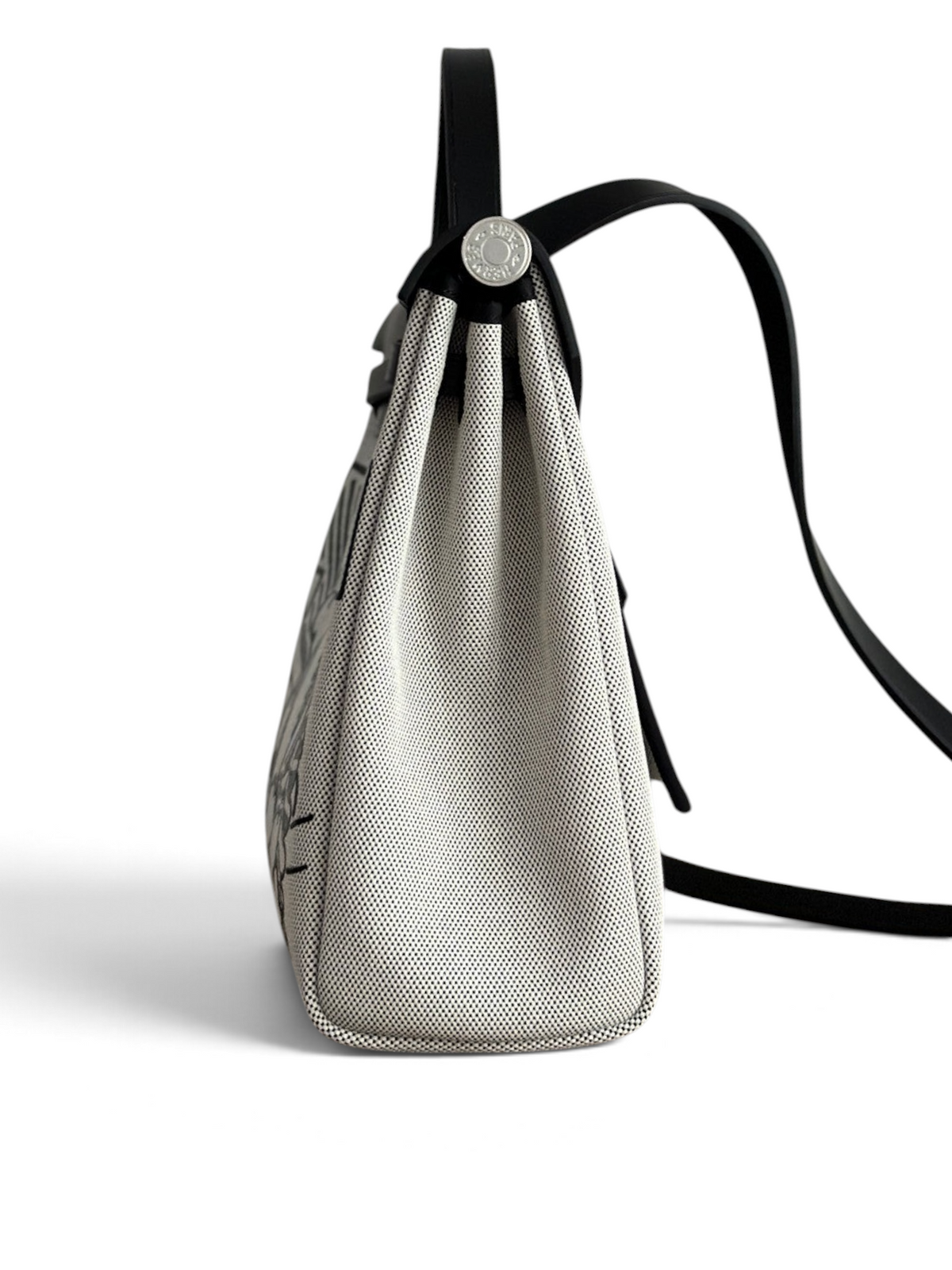 SWORD LUXURY Herbag 31 çanta, siyah deri detaylı ve sanatsal baskılı kanvas gövdesiyle yandan görünüm.