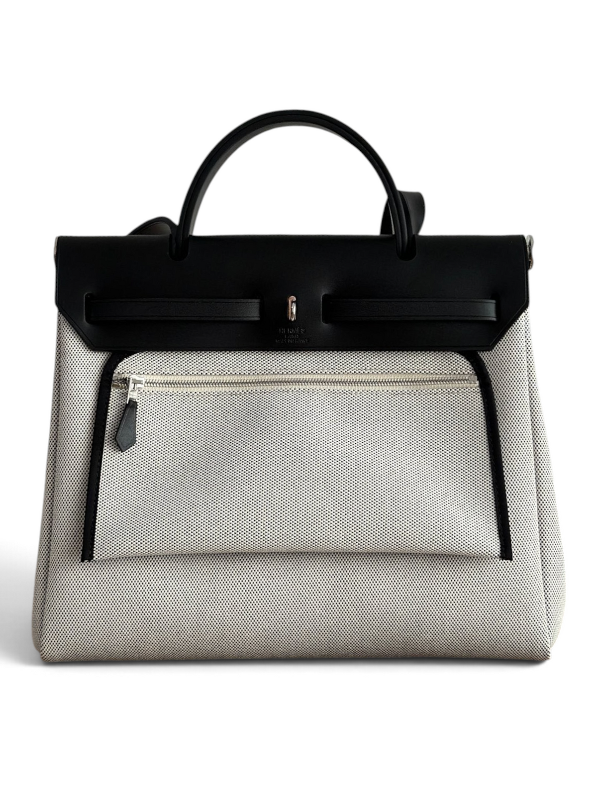 SWORD LUXURY Hermès Herbag 31 çanta, siyah deri kapaklı ve bej kanvas gövdeli, şık ve yapılandırılmış tasarım.