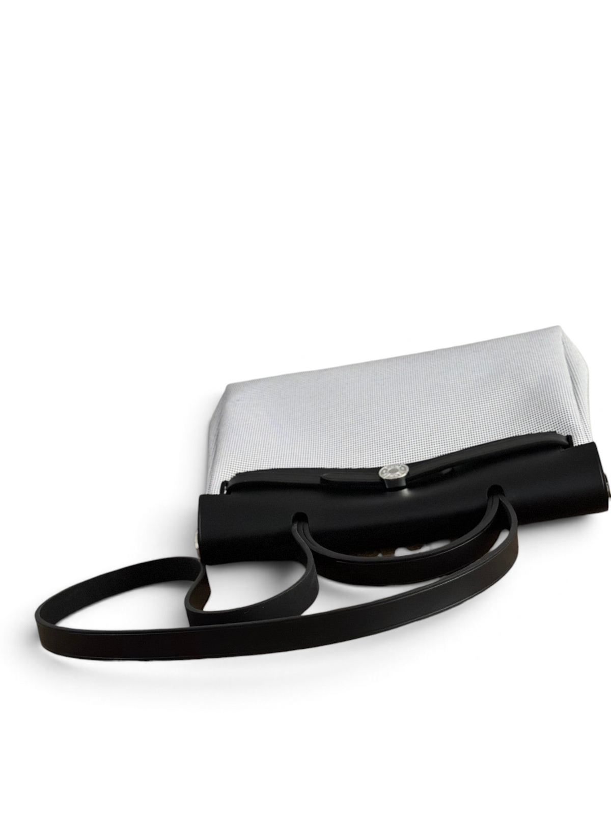 SWORD LUXURY Herbag 31 çanta, siyah deri kapaklı ve beyaz kanvas gövdeli, şık ve modern bir tasarım.