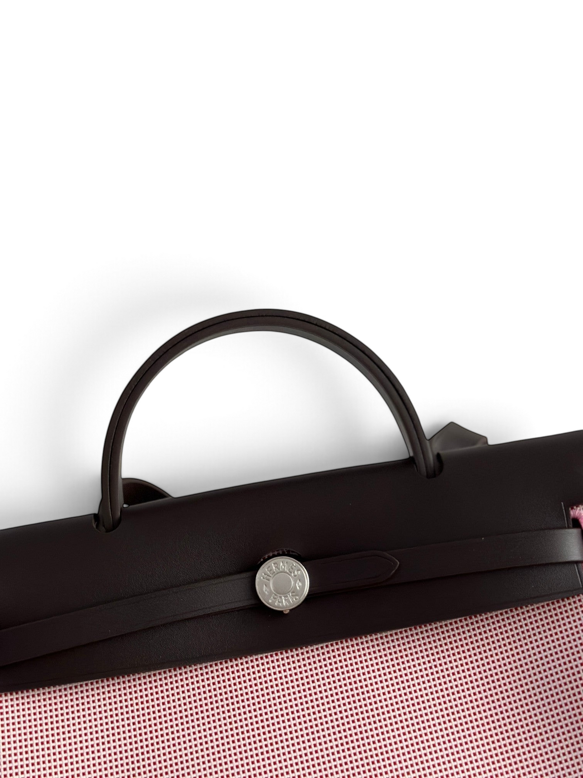 SWORD LUXURY Hermès Herbag 31 çanta, koyu kahverengi deri kapaklı ve gümüş Clou de Selle detaylı, şık kanvas gövdeli.