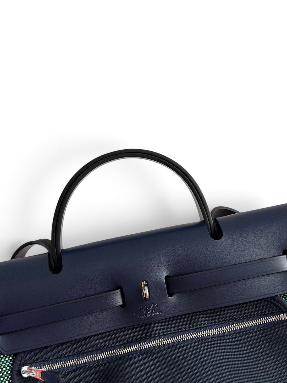 SWORD LUXURY marka lacivert deri ve kanvas Hermès Herbag 31 çanta, Clou de Selle kapamalı deri üst kapak detayı.