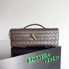 Quilted handbag with gold clasp on a reflective surface with Bottega Veneta branding.