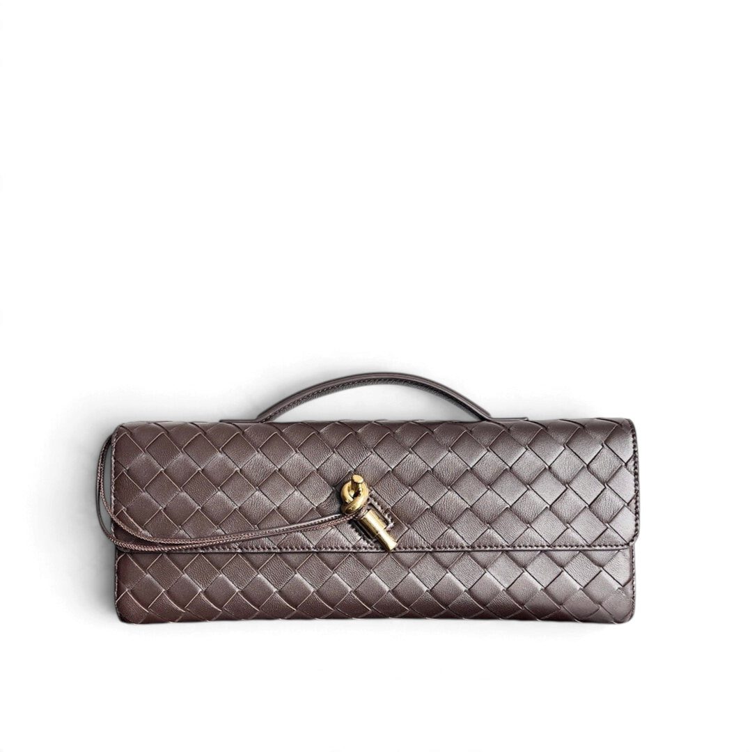 Quilted handbag with gold clasp on a reflective surface with Bottega Veneta branding.