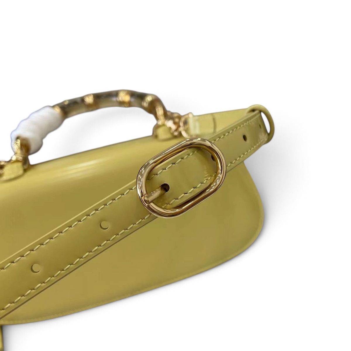 SWORD LUXURY Gucci Bamboo 1947 mini çanta, sarı deri detayları ve ayarlanabilir omuz askısı tokası ile yakından görünüm.