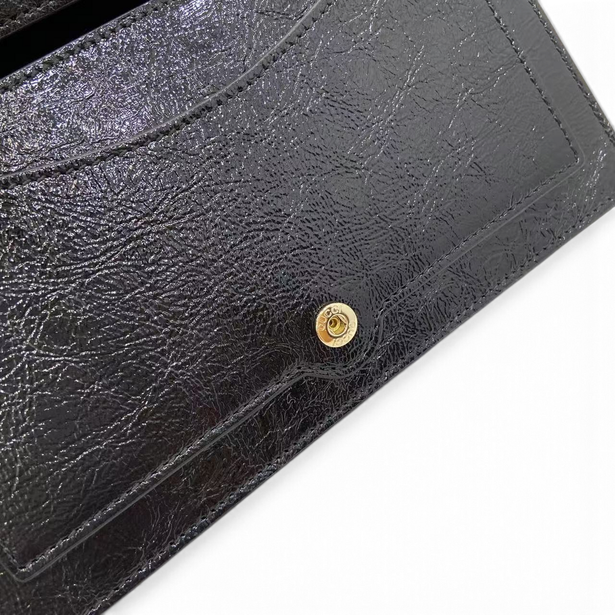 SWORD LUXURY Gucci Dionysus Super Mini çanta, parlak siyah deri dokusu ve altın tonlu çıtçıt detaylı iç kapak.