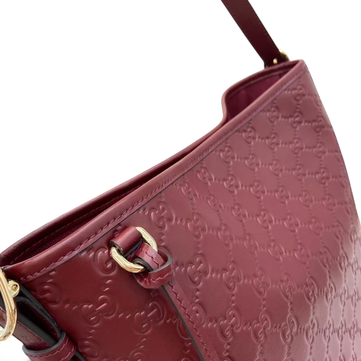 SWORD LUXURY bordo renkli, GG monogram kabartmalı deri omuz çantası, altın tonlu metal detaylara sahip.