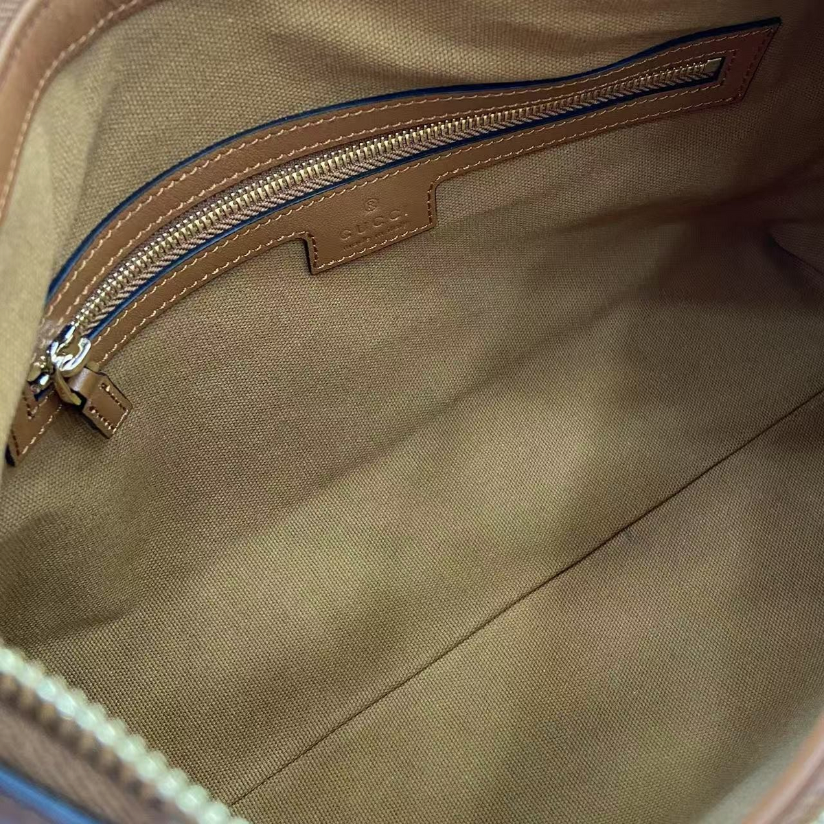 SWORD LUXURY Gucci GG amblemli deri omuz çantasının iç kısmı, fermuarlı bölmesi ve kaliteli kumaş astarı ile.
