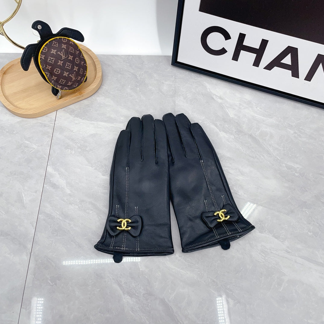 Black gloves with bow and Chanel logo on a light gray surface, with 'Chanel' branding in the background.
