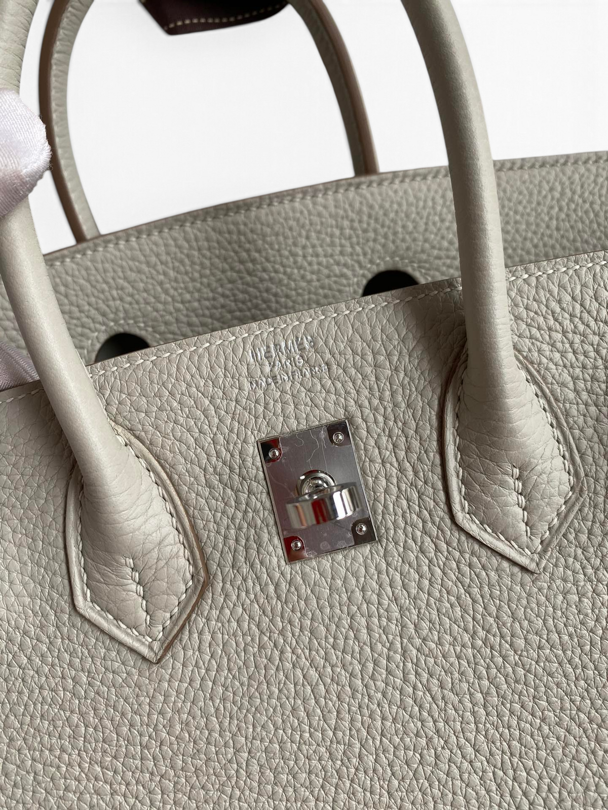 SWORD LUXURY Hermès Birkin 30 gri Togo deri çanta, gümüş donanım ve ikonik kilit detayı ile yakın çekim.