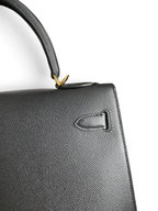 SWORD LUXURY marka siyah Epsom deri Hermès Kelly 32cm çanta, detaylı dokusu ve altın rengi metal aksesuarlarıyla.