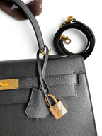 SWORD LUXURY siyah Epsom deri Hermès Kelly 32cm çanta, altın rengi kilit ve çıkarılabilir omuz askısı detaylı.