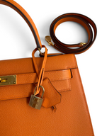 SWORD LUXURY turuncu Epsom deri Hermès Kelly 32cm çanta, altın donanım, kilit ve çıkarılabilir omuz askısı detaylı.