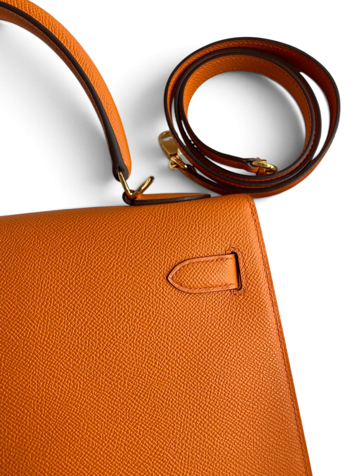 SWORD LUXURY marka turuncu Epsom deri Hermès Kelly 32cm çanta, detaylı dokusu ve altın rengi metal aksamları ile.