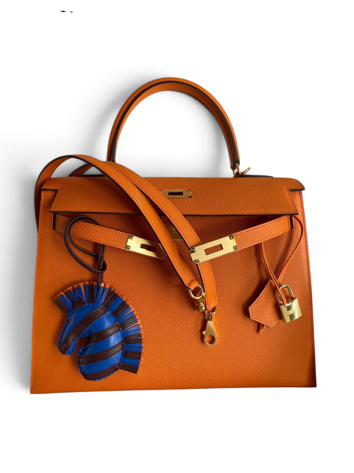 SWORD LUXURY turuncu Epsom deri Hermès Kelly 32cm çanta, altın donanım, kilit, anahtarlar ve zebra çanta süsü ile.