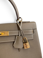 SWORD LUXURY marka, gri Epsom deri Hermès Kelly 32cm çanta, altın rengi kilit ve detaylara sahip.