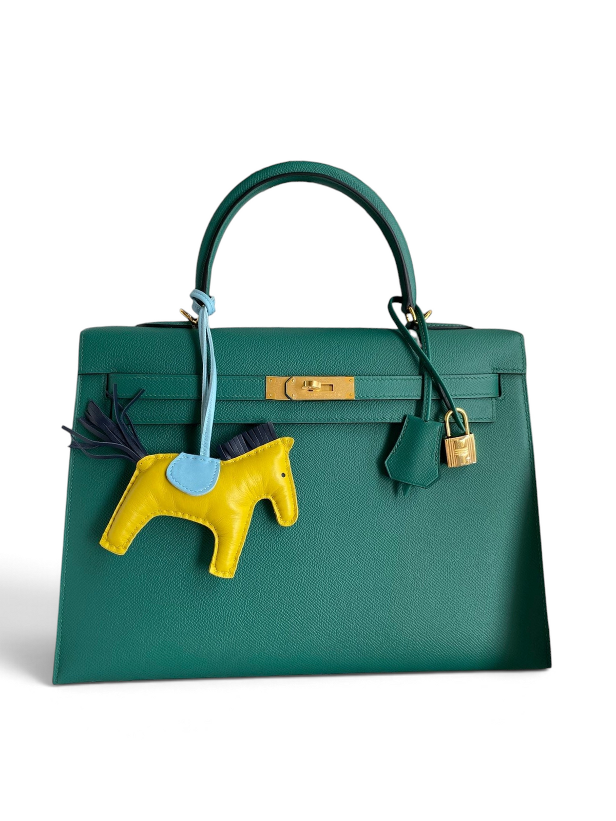 SWORD LUXURY marka, yeşil Epsom deri Hermès Kelly 32cm çanta, altın donanım ve sarı at figürlü çanta aksesuarı ile.