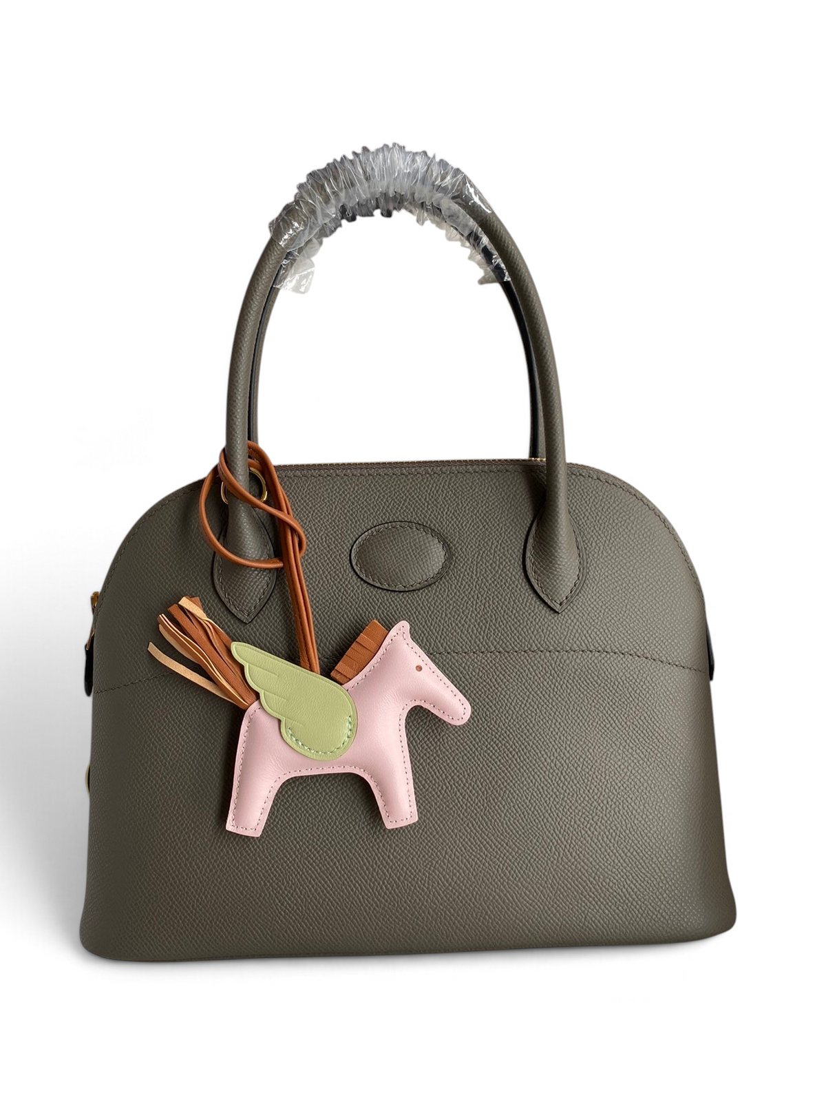 SWORD LUXURY gri Epsom deri Hermès Bolide 27cm çanta, üzerinde pembe kanatlı at figürlü çanta süsü ile.