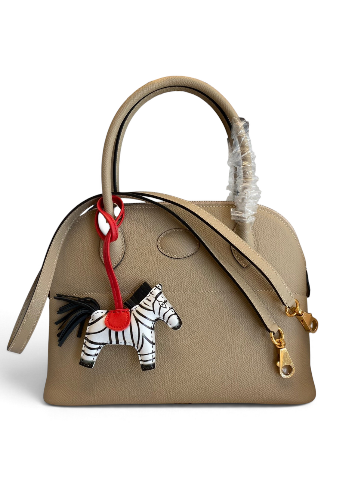 SWORD LUXURY marka, bej renkli, Epsom deri Hermès Bolide 27cm çanta, üzerinde zebra figürlü çanta süsü ile.