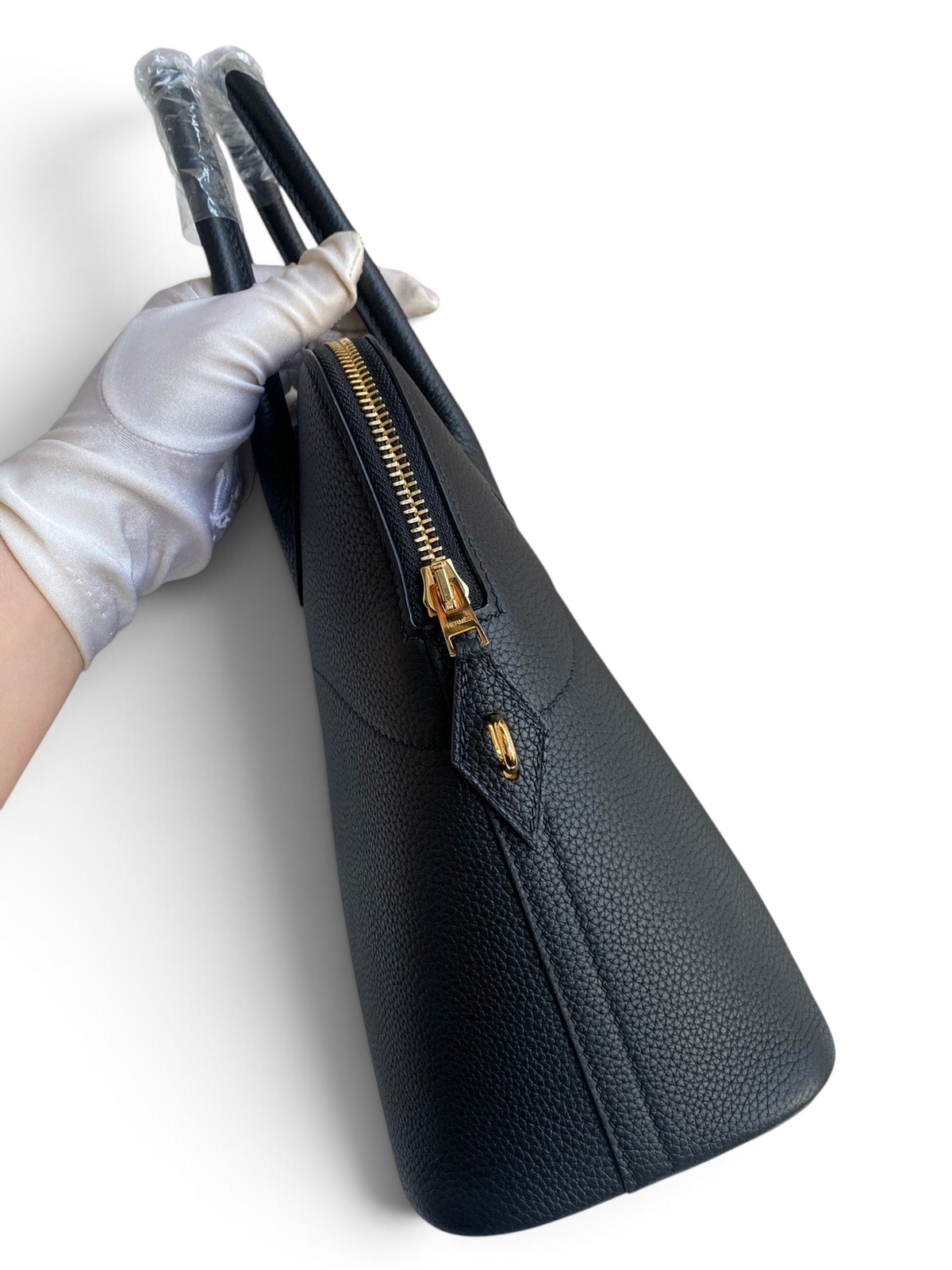 SWORD LUXURY imzalı, siyah Togo deri Hermès Bolide 31cm çanta, altın rengi fermuar detaylı ve elde tutuluyor.