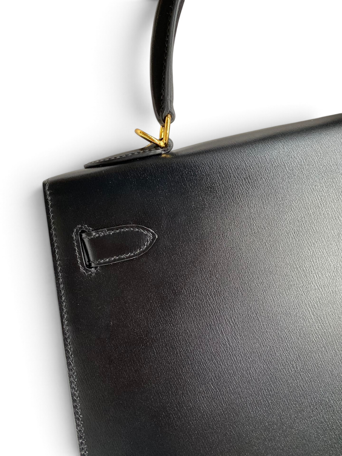 SWORD LUXURY siyah box deri Hermès Kelly 32cm çanta detayı, altın rengi metal aksamlı ve pürüzsüz deri dokulu.