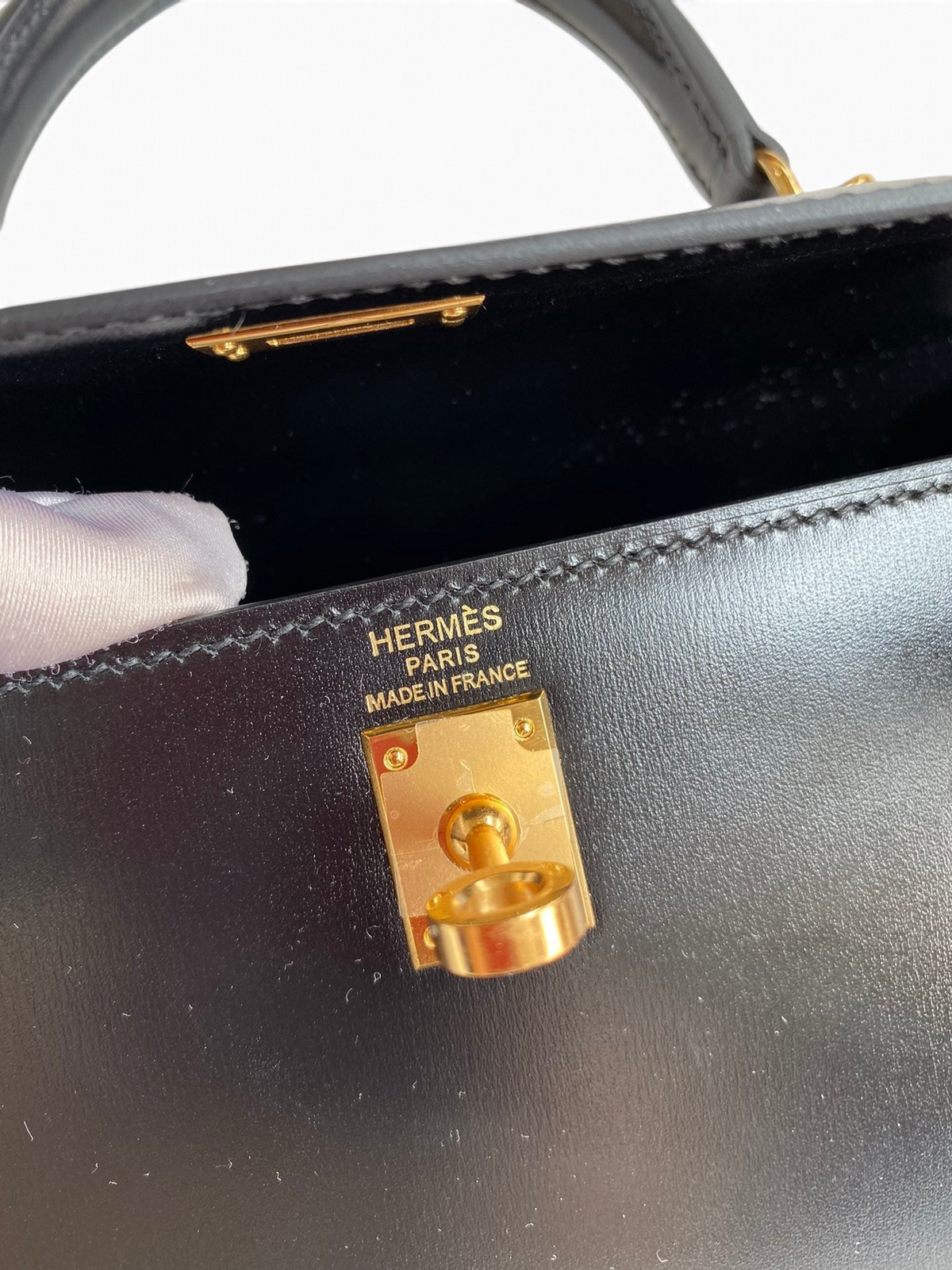 SWORD LUXURY Hermès Kelly 25cm çanta, altın rengi kilit detayı ve pürüzsüz siyah box deri iç tasarımı.