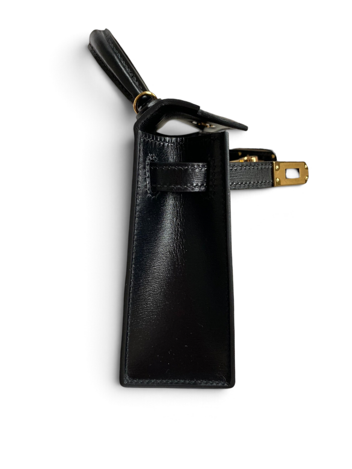SWORD LUXURY marka siyah box deri Hermès Mini Kelly 19cm çanta, yan profil görünümü ve altın tonlu metal detaylar.