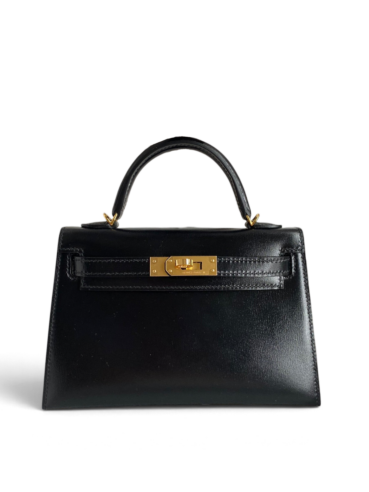 SWORD LUXURY marka, altın donanımlı, siyah box deri Hermès Mini Kelly 19cm çanta, kutusu içinde sergileniyor.