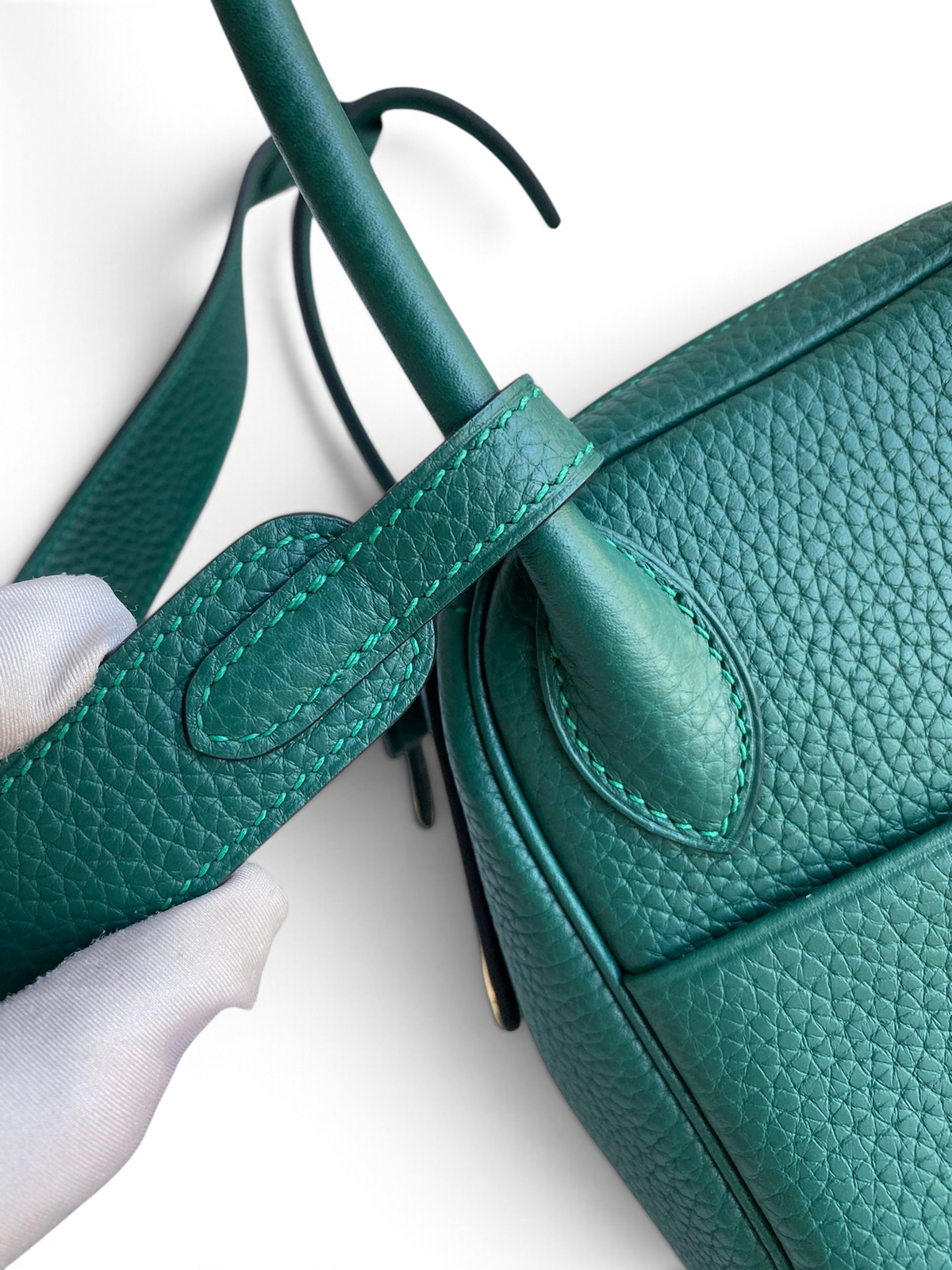 SWORD LUXURY marka yeşil Clemence deri Lindy 26 çanta detayı, eldivenli elle tutulan sap ve dikiş yapısı.