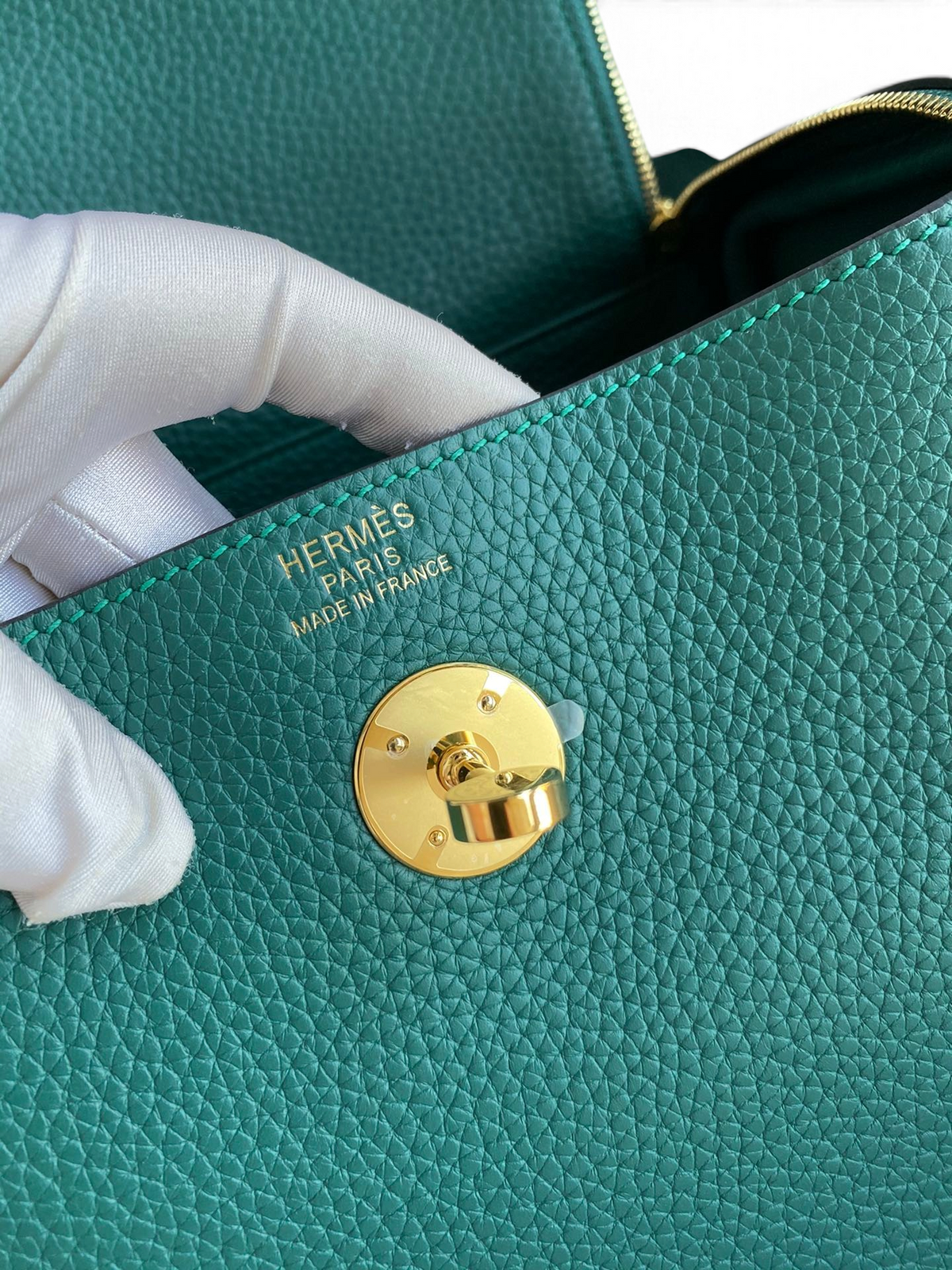 SWORD LUXURY Hermès Lindy 26 çanta, altın rengi kilit detayı ve dokulu yeşil Clemence deri detaylı iç kısım.