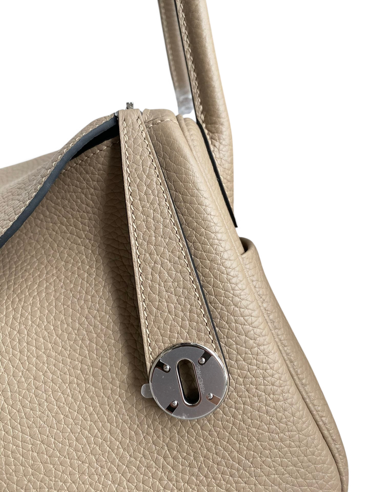 SWORD LUXURY bej renkli Clemence deri Hermès Lindy 26 çanta, gümüş tonlu metal detaylı ve dokulu deri yüzeyli.