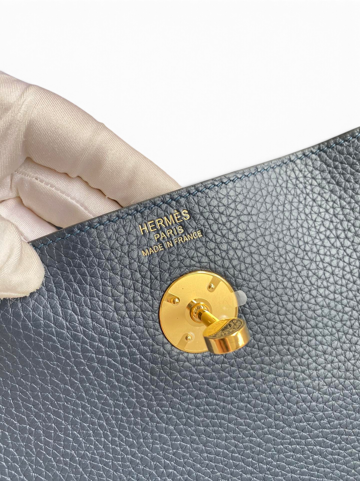 SWORD LUXURY Hermès Lindy 26 çanta üzerinde altın tonlu metal kilit detayı ve deri dokusu yakın çekimi