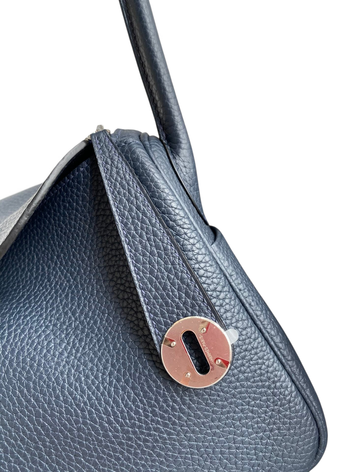 SWORD LUXURY lacivert Clemence deri Hermès Lindy 26 çanta, gümüş tonlu metal kilit detayı ile yakın çekim.