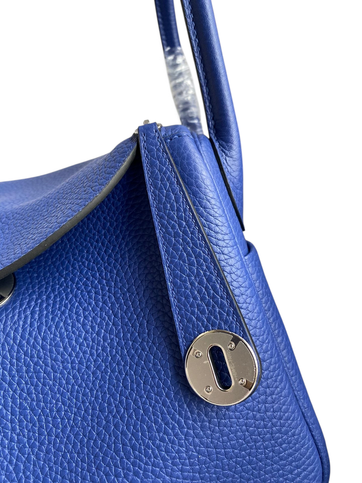 SWORD LUXURY marka, parlak mavi Clemence deriden üretilmiş, gümüş donanımlı ve ikonik kilit detaylı Lindy 26 çanta.