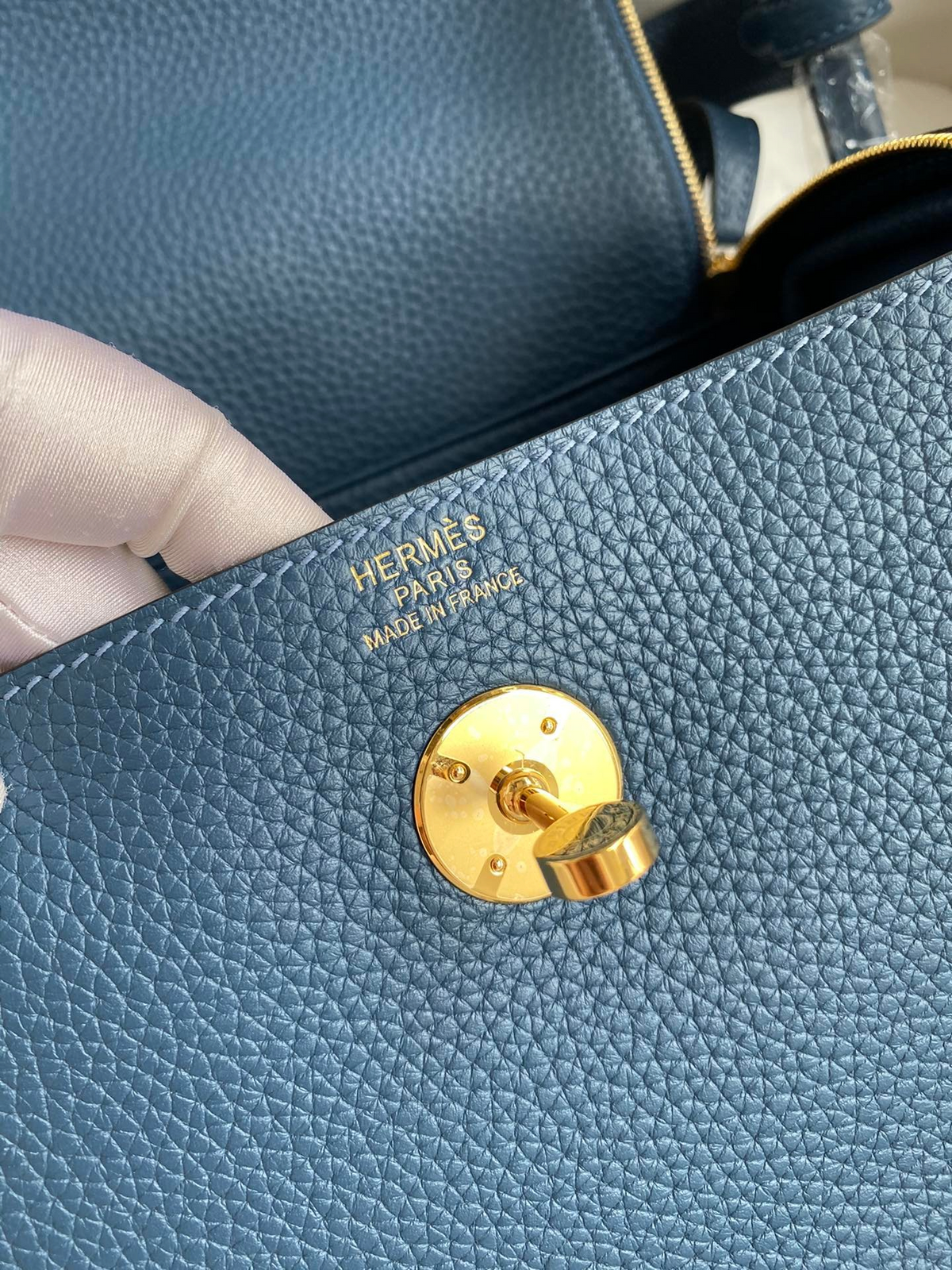 SWORD LUXURY Hermès Lindy 26 çanta üzerinde altın tonlu metal kilit detayı ve deri dokusu