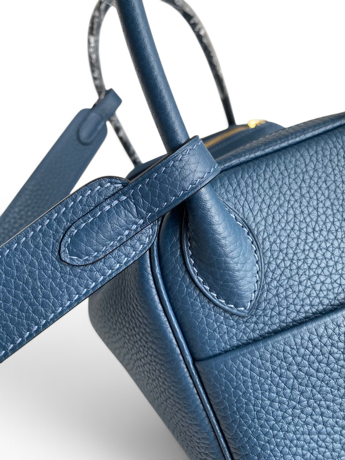 SWORD LUXURY marka mavi Clemence deri Hermès Lindy 26 çanta detayı, dikişli sap ve omuz askısı görünümü.