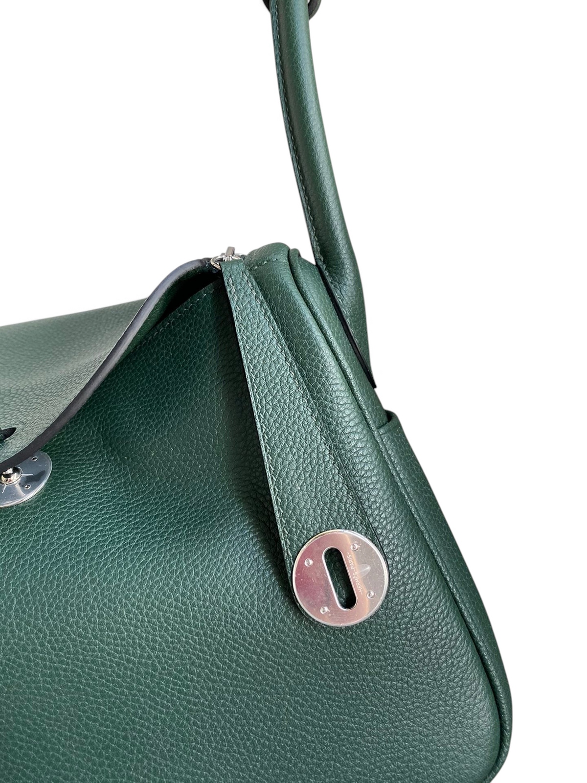SWORD LUXURY marka, koyu yeşil Clemence deri Hermès Lindy 26 çanta, gümüş metal detaylı ve ikonik kilitli tasarım.