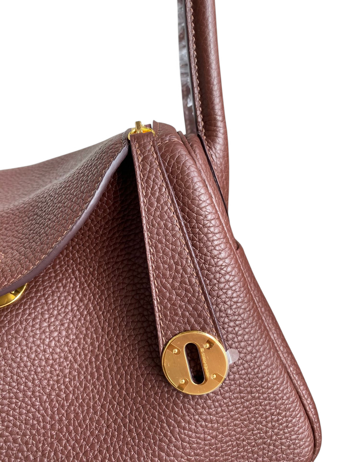 SWORD LUXURY kahverengi Clemence deri Hermès Lindy 26 çanta, altın rengi metal detaylı ve ikonik kilit mekanizmalı.