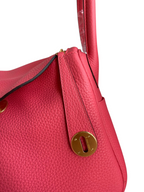 SWORD LUXURY pembe Clemence deri Hermès Lindy 26 çanta, altın tonlu metal detaylar ve ikonik kilit mekanizması.