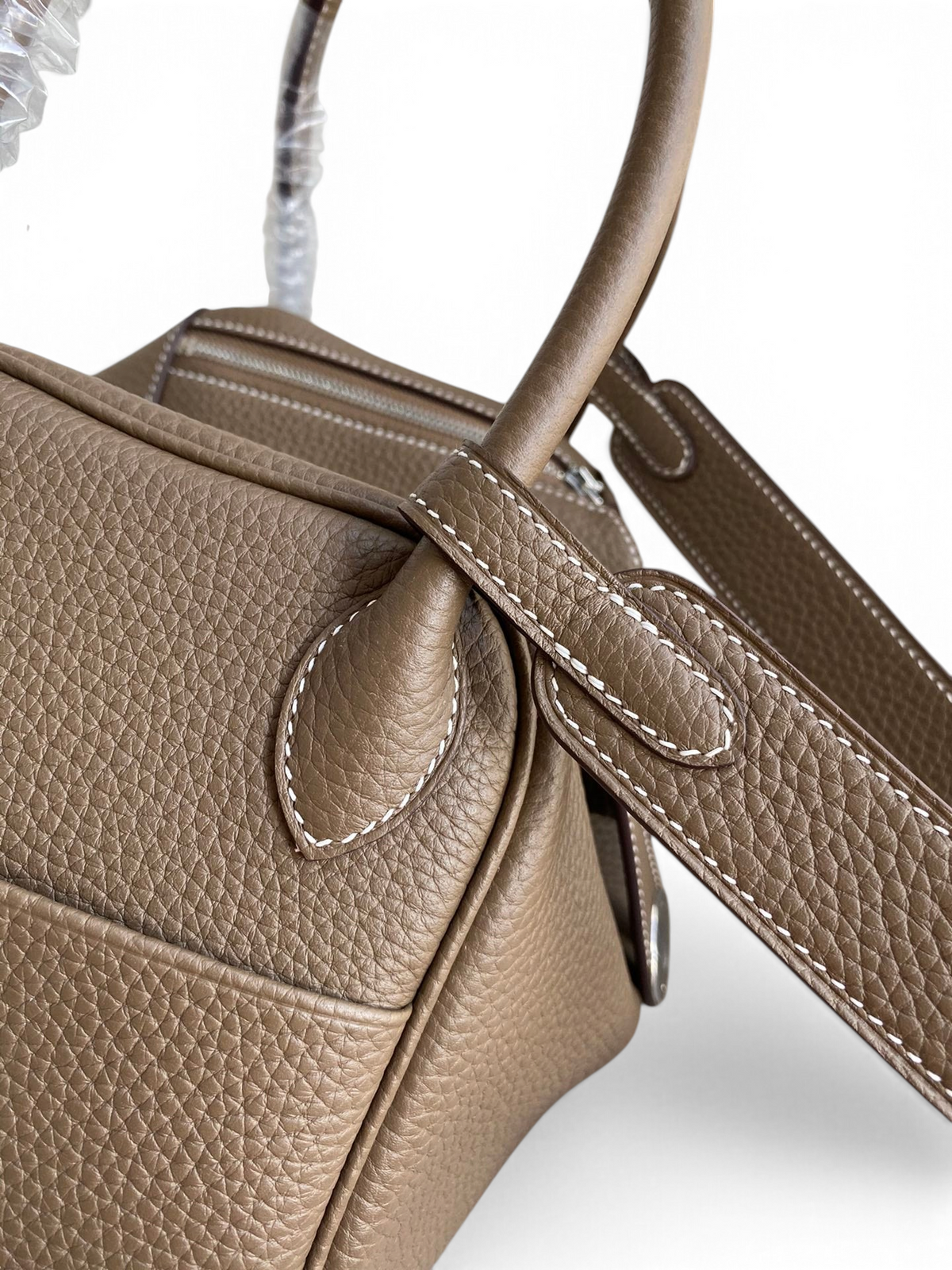 SWORD LUXURY marka, vizon rengi Clemence deri Hermès Lindy 26 çanta, detaylı dikişleri ve omuz askısı ile yakın çekim.