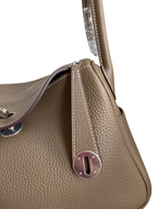 SWORD LUXURY marka, taupe renkli, Clemence deri Hermès Lindy 26 çanta, metal detaylı ve dikişli tasarım.