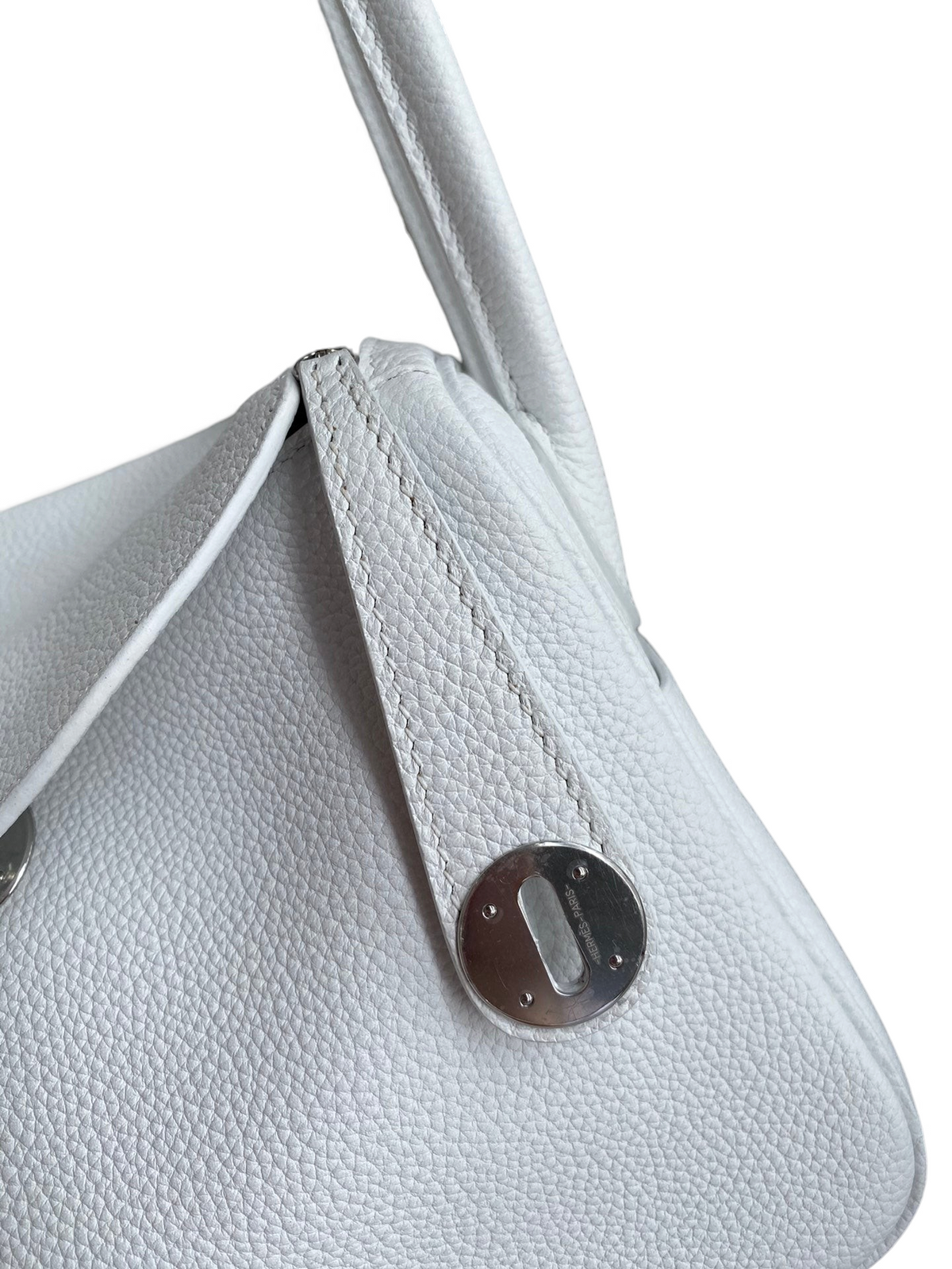 SWORD LUXURY beyaz Clemence deri Hermès Lindy 26 çanta, gümüş donanımlı kapak ve ikonik döner kilit detayı.
