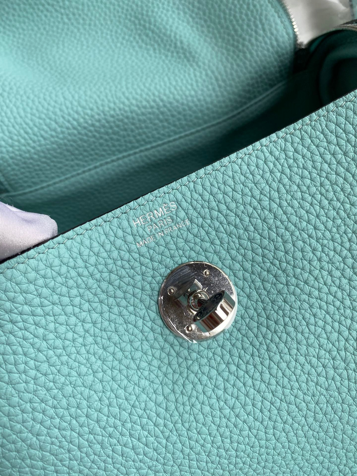SWORD LUXURY Hermès Lindy 26 çanta, turkuaz Clemence deri dokusu ve gümüş renkli metal döner kilit detayı.