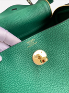 SWORD LUXURY Hermès Lindy 26 çanta, yeşil Clemence deri detayları, altın rengi kilit ve iç logo baskısı.