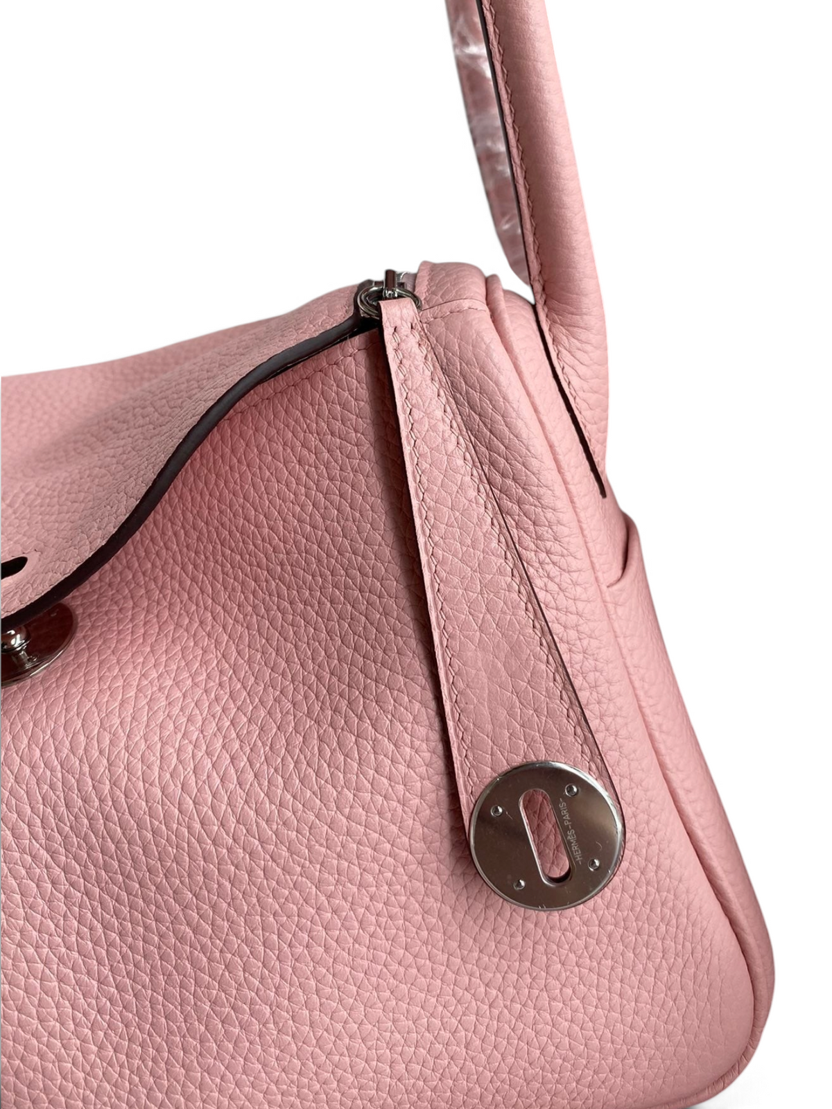 SWORD LUXURY marka pembe Clemence deri Hermès Lindy 26 çanta, gümüş donanımlı ve ikonik kilit detaylı yakın çekim.