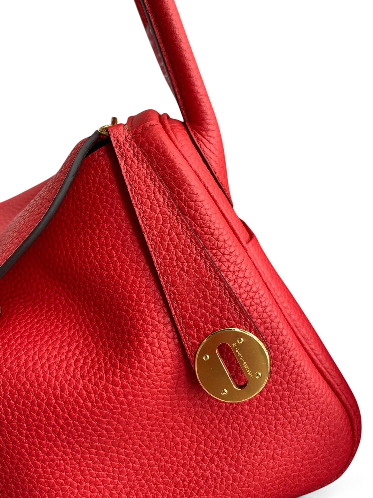 SWORD LUXURY kırmızı Clemence deri Hermès Lindy 26 çanta, altın tonlu metal kilit detayı ve dokulu yüzey.